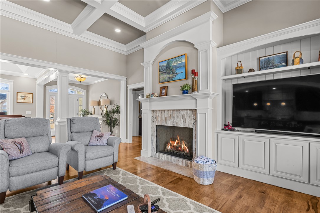 209 Crestridge Drive Seneca, SC 29672 - Photo 8 of 49 This living room features rich wood flooring, a fireplace, and elegant ceiling details.