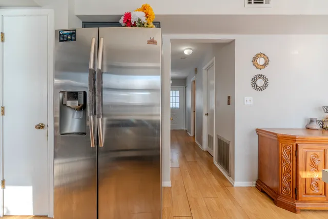 a kitchen with a refrigerator and wooden floor