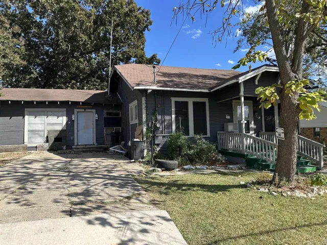 a view of a house with a tree in front of it