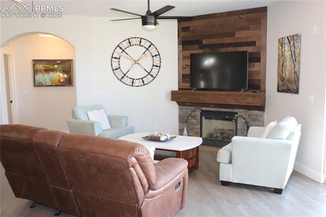 2473 Cinnabar Road Colorado Springs, CO 80921 - Photo 12 of 22 Great room with views of Pikes Peak, updated gas fireplace with stone and wood mantle. Also newly refinished hardwood floors and new paint