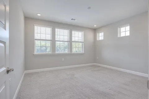 an empty room with windows and closet