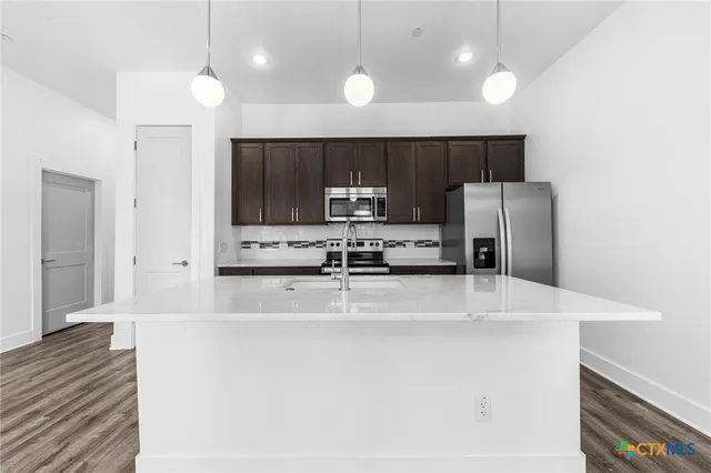 a kitchen with stainless steel appliances a refrigerator sink and stove
