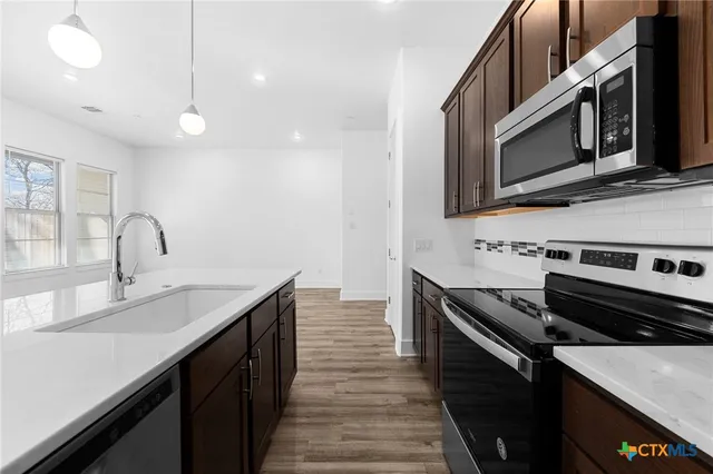 a kitchen with stainless steel appliances a sink and a microwave