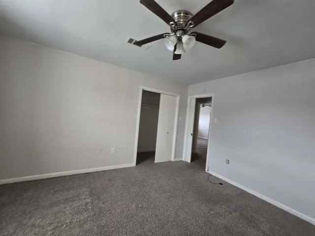 an empty room with chandelier fan