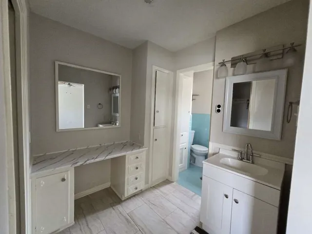 a bathroom with a double vanity sink mirror and shower