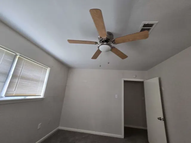 a view of a room with a window and wooden floor
