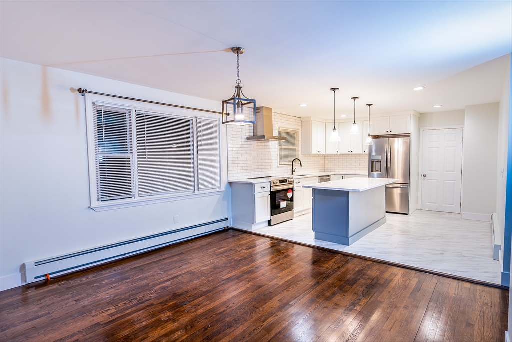 1560 West Main Road Middletown, RI 02842 - Photo 2 of 18 a large kitchen with stainless steel appliances kitchen island a large counter top and wooden floors