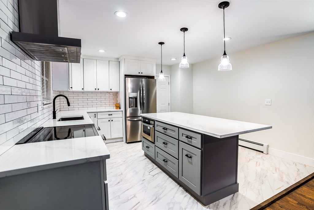 1560 West Main Road Middletown, RI 02842 - Photo 4 of 18 a kitchen with stainless steel appliances a sink stove and refrigerator