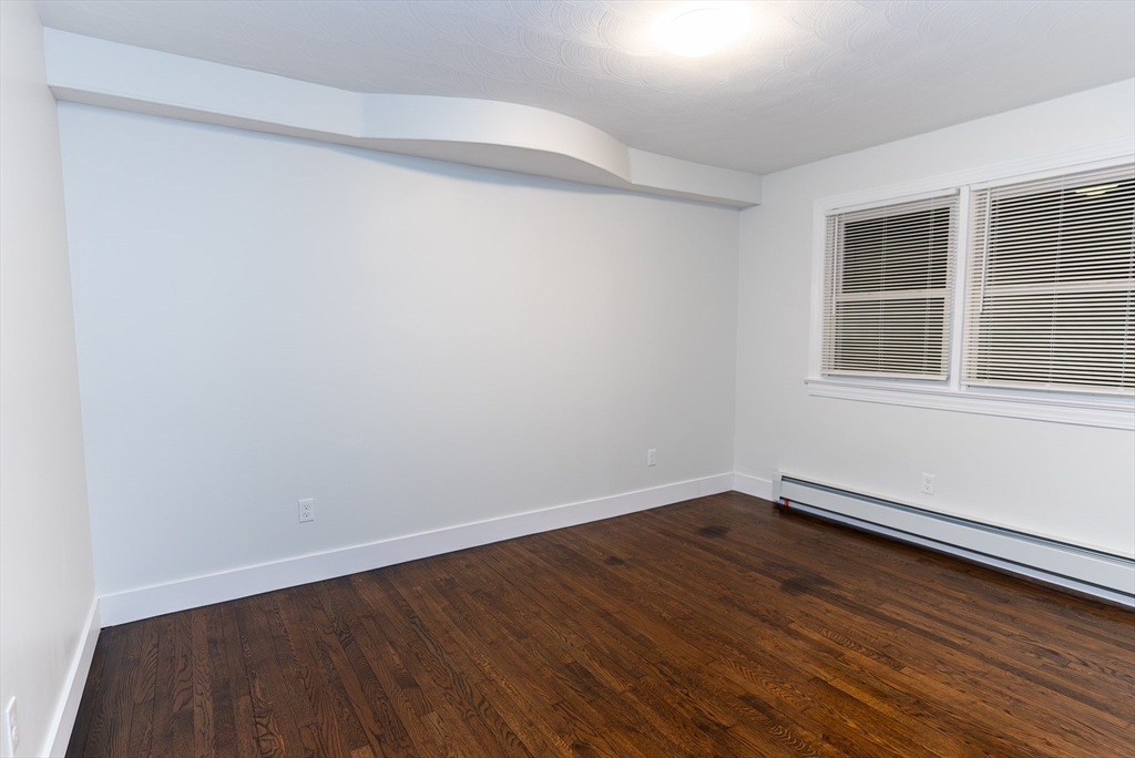 1560 West Main Road Middletown, RI 02842 - Photo 8 of 18 an empty room with wooden floor and windows