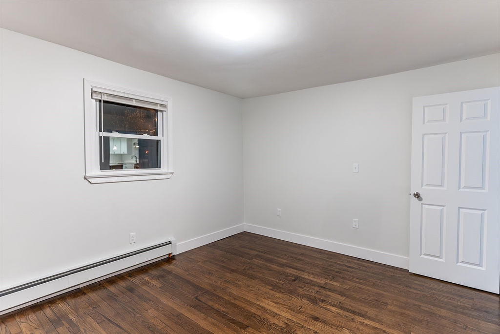 1560 West Main Road Middletown, RI 02842 - Photo 10 of 18 a view of an empty room with wooden floor and a window