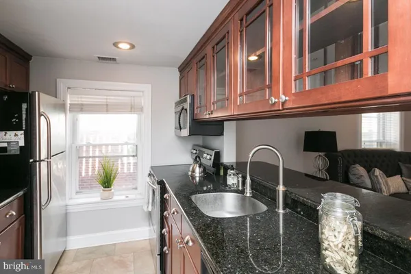 a kitchen with granite countertop a sink and a refrigerator