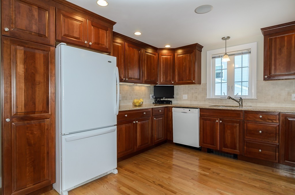 15 Virginia Road Arlington, MA 02476 - Photo 8 of 21 a kitchen with stainless steel appliances granite countertop a refrigerator a sink dishwasher and wooden cabinets with wooden floor