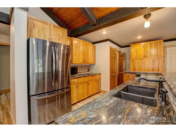 a kitchen with stainless steel appliances granite countertop a refrigerator a sink a stove with wooden cabinets