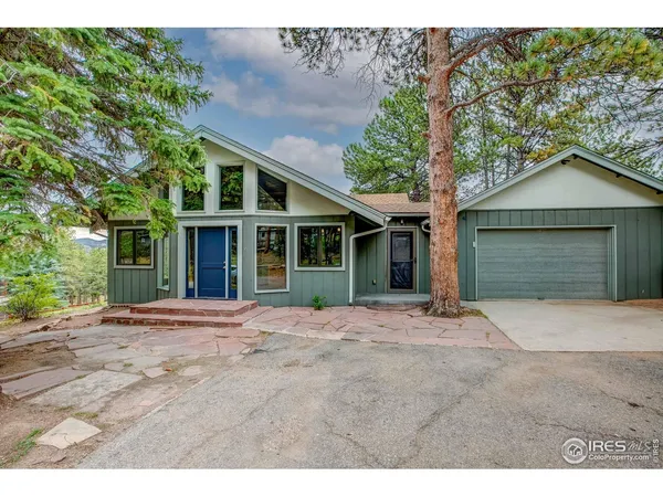 a front view of a house with a garden and trees