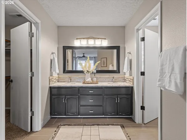 a bathroom with a granite countertop sink and a mirror