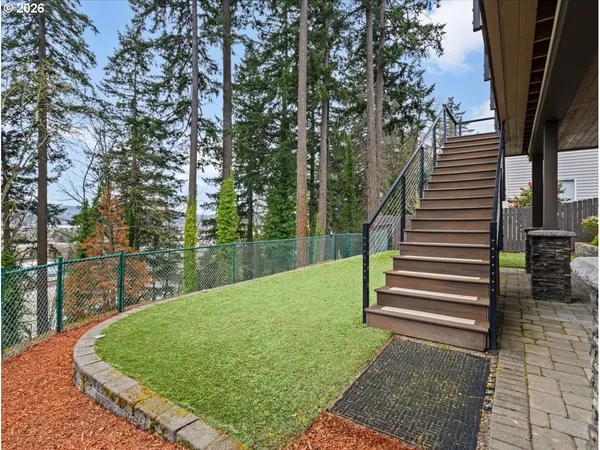 a view of a house with a yard and a wooden fence