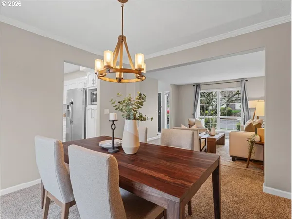 a dining room with furniture a chandelier and window