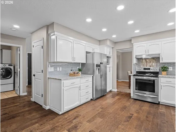 a kitchen with white cabinets and stainless steel appliances