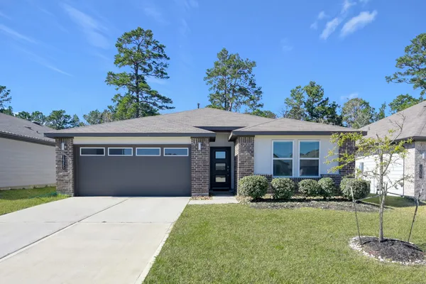 a front view of a house with a garden and yard