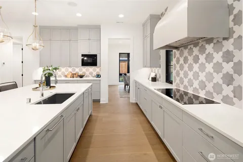 a kitchen with a dining table chairs stainless steel appliances and kitchen view