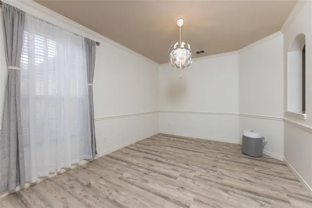 a view of a room with wooden floor and a window