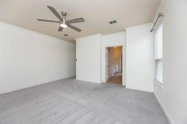 a view of an empty room with a ceiling fan