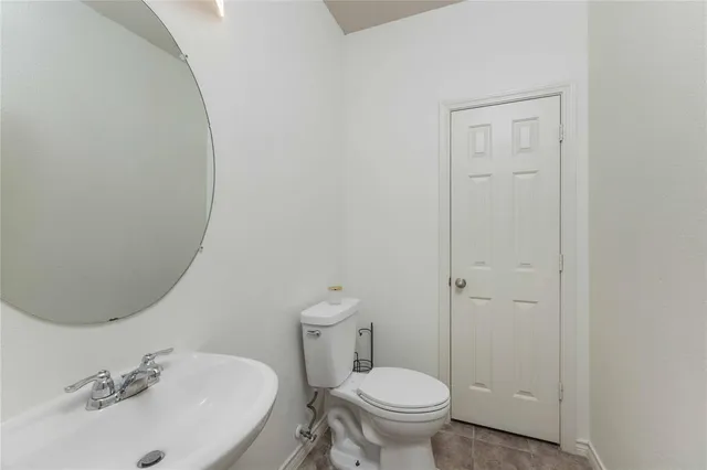 a bathroom with a sink toilet and a mirror