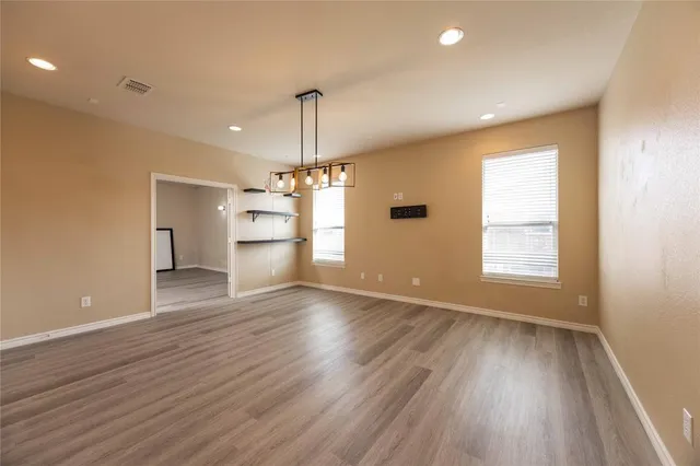 a view of empty room with wooden floor and window