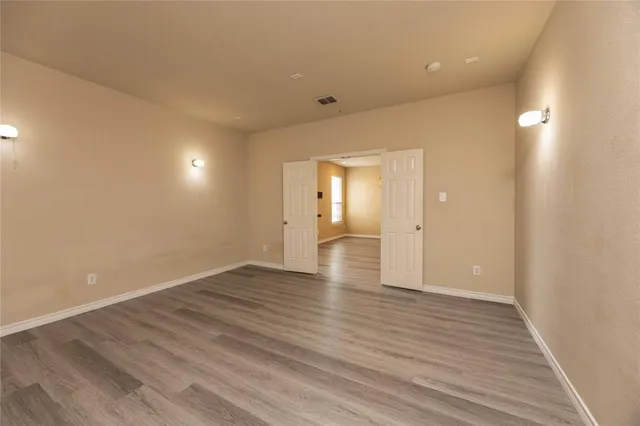 a view of an empty room with wooden floor