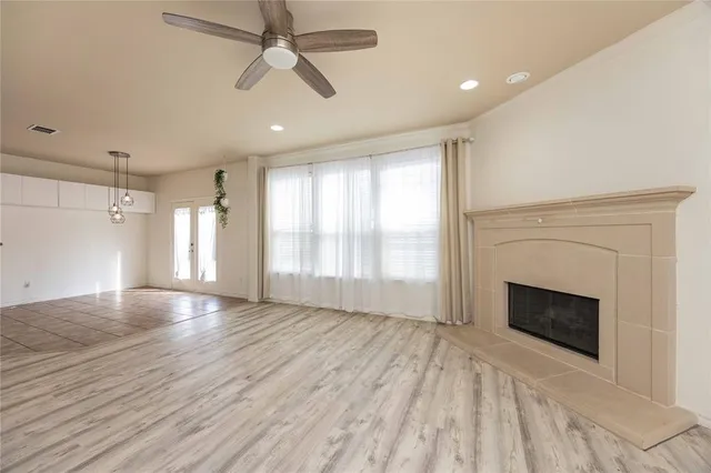 wooden floor fireplace and windows in an empty room