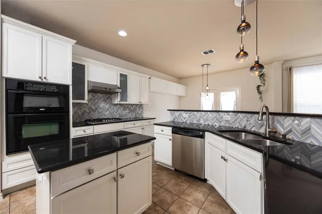 a kitchen with granite countertop a sink stainless steel appliances and cabinets