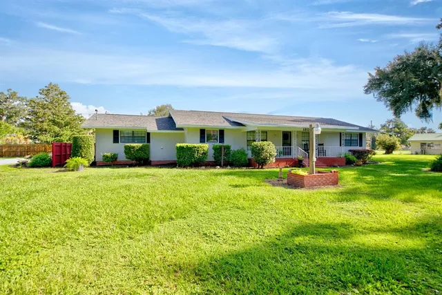 a view of a house with a big yard and potted plants