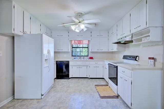 a kitchen with lot of cabinets and refrigerator