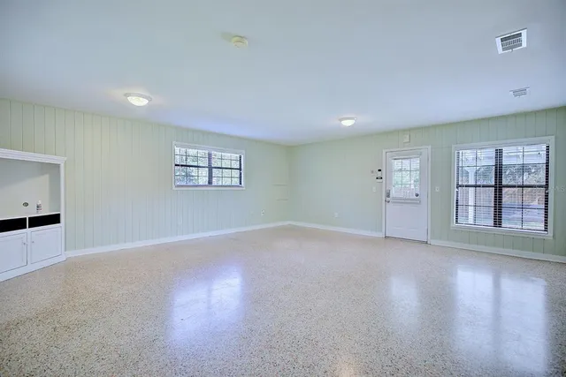 an empty room with windows and entrance