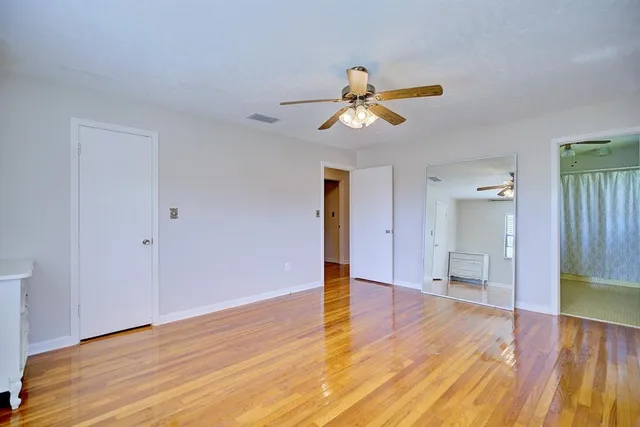 a view of a room with wooden floor and ceiling fan