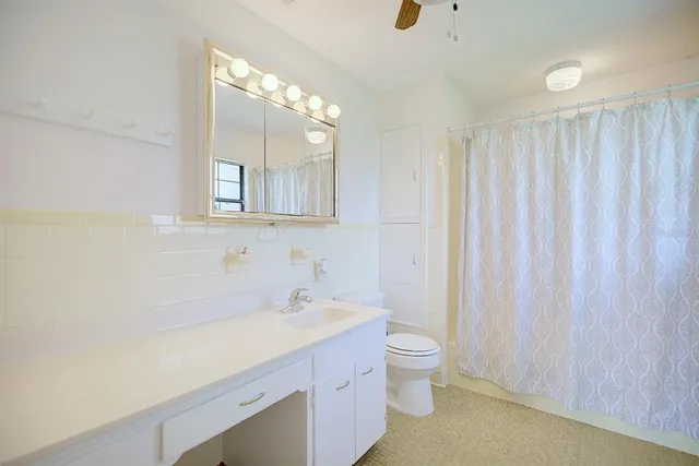 a bathroom with a double vanity sink toilet and a mirror