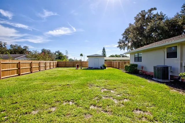 a view of a house with backyard and sitting area