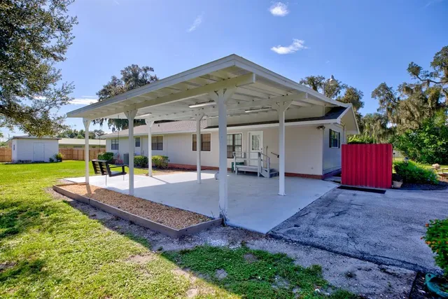 a view of a house with backyard and sitting area