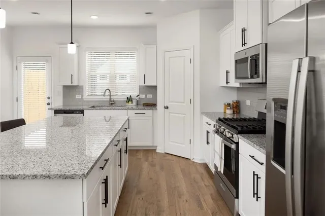 a kitchen with stainless steel appliances granite countertop a sink stove and refrigerator
