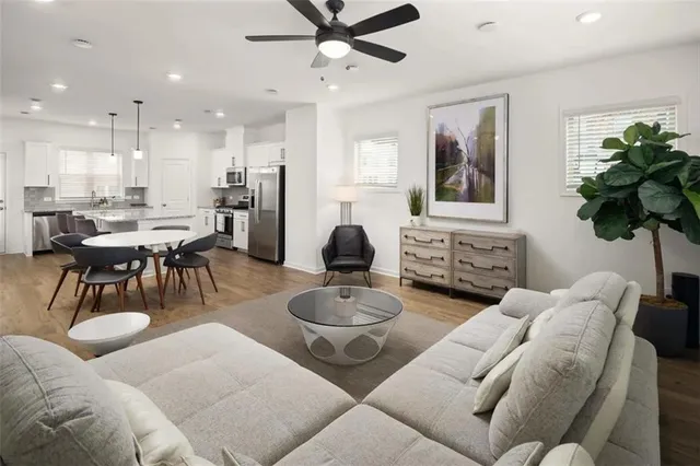 a living room with furniture a chandelier and a dining room