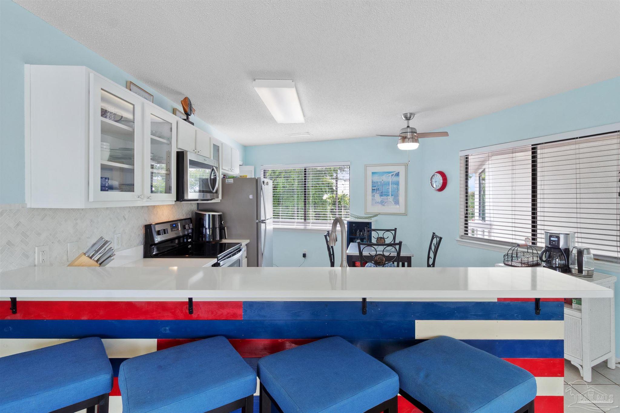285 Payne Street, Unit 21B Miramar Beach, FL 32550 - Photo 12 of 42 a kitchen with a dining table and chairs