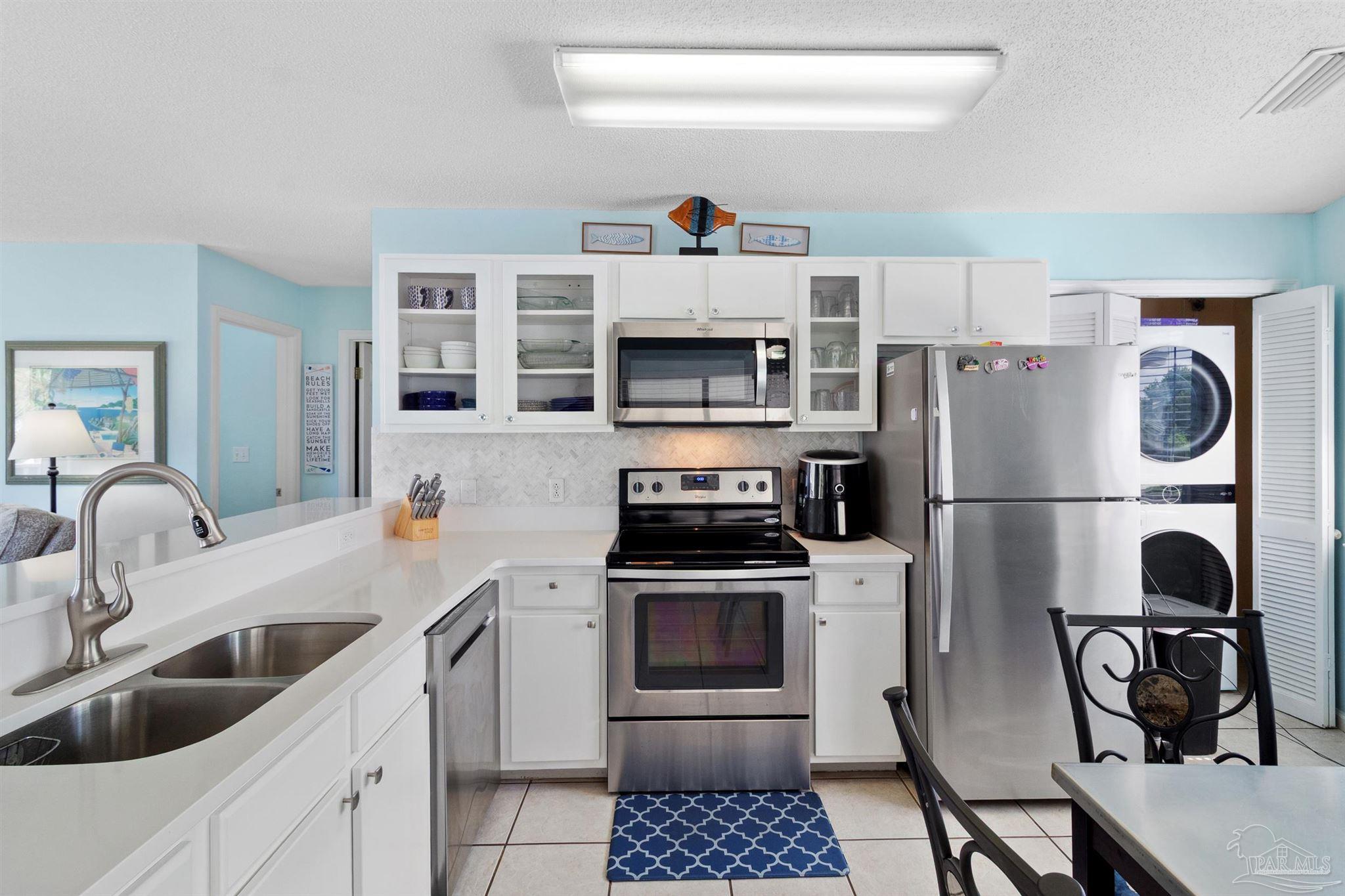 285 Payne Street, Unit 21B Miramar Beach, FL 32550 - Photo 13 of 42 a kitchen with stainless steel appliances a microwave a sink a stove and a refrigerator