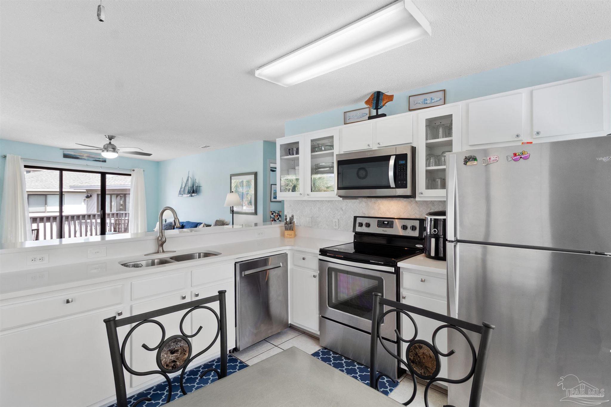 285 Payne Street, Unit 21B Miramar Beach, FL 32550 - Photo 14 of 42 a kitchen with stainless steel appliances a stove a sink and a refrigerator