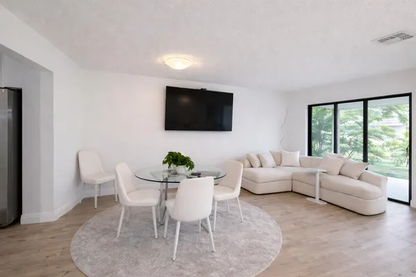 a living room with furniture a flat screen tv and a large window