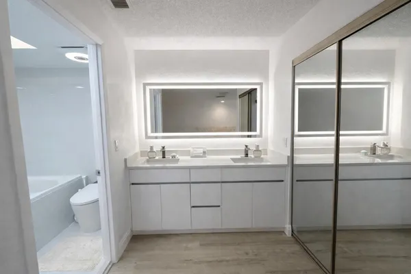 a bathroom with a toilet sink and mirror
