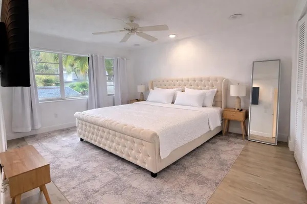 a large bedroom with a bed and a large window