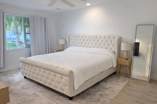 a large bed sitting in a bedroom next to a window