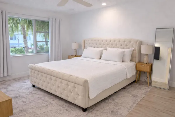 a large bed sitting in a bedroom next to a window