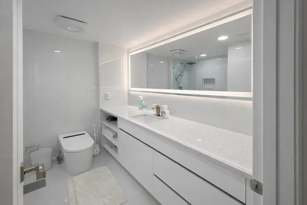 a bathroom with a toilet sink and mirror