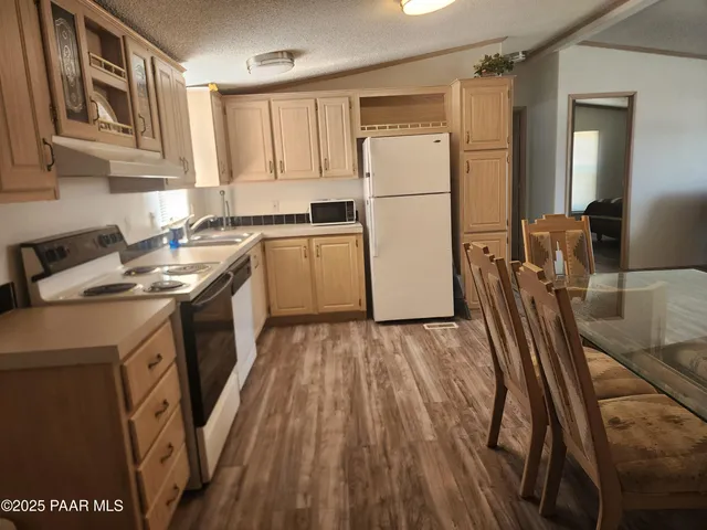 a kitchen with a refrigerator a stove top oven a sink and dishwasher